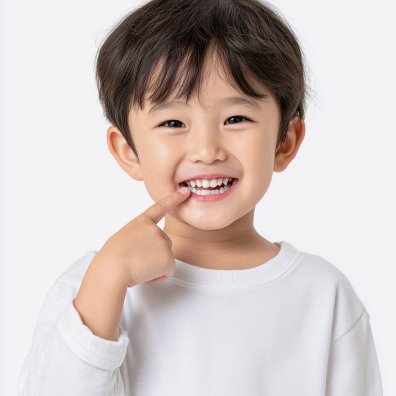 환하게 웃으며 앞니를 가리키는 어린아이